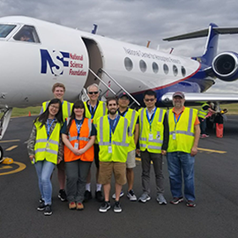 professor and students standing in front of an airplane